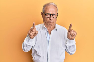 Kafkasyalı kıdemli bir adam şüpheci ve gergin parmaklarıyla işaret ediyor, sorun yüzünden kaşlarını çatıyor. negatif kişi. 