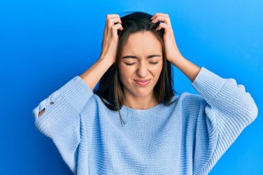 Genç İspanyol kız gündelik kıyafetler giyiyor. Baş ağrısı çekiyor. Acı ve migren yüzünden çaresiz ve stresli. Eller başının üstünde.. 