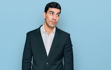 Yakışıklı, iş kıyafetleri giymiş, gülümseyen, yan bakıp düşünen bir İspanyol.. 