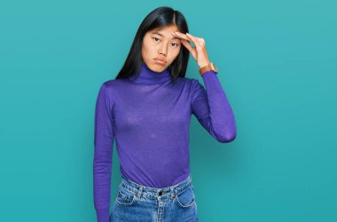 Güzel, genç Asyalı kadın gündelik kıyafetler giyiyor. Alnındaki sorun yüzünden endişeli ve stresli. Kriz için endişeli. 