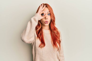 Genç, güzel, kızıl saçlı, sıradan bir kazak giyen, şaşırmış yüzüyle şaşırmış, parmaklarından bakan bir jest yapan bir kadın. İnançsız ifade. 