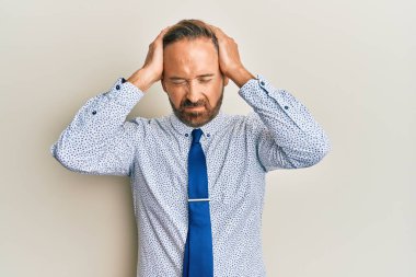 Yakışıklı, orta yaşlı, iş gömleği giyen, kravatlı, baş ağrısı çeken çaresiz ve stresli bir adam. Çünkü ağrı ve migren ağrısı var. Eller başının üstünde.. 