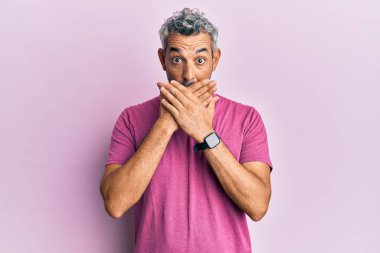 Orta yaşlı, gri saçlı, günlük kıyafetler giyen bir adam ağzı yanlışlıkla ellerle kapatırken şok geçirdi. gizli kavram. 