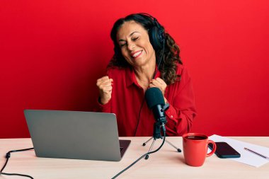 Radyo stüdyosunda çalışan güzel, orta yaşlı bir kadın kolları havada ve gözleri kapalı zaferi kutlarken heyecanla bekliyor. Kazanan konsept. 