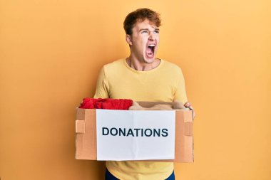 Kafkasyalı genç bir adam bağış kutusunu elinde tutuyor kızgın ve öfkeli çığlıklar atıyor öfkeyle bağırıyor, öfkeyle yukarı bakıyor.. 