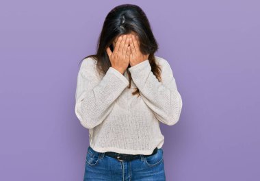 Güzel İspanyol kadın, ağlarken suratını ellerle kapatan sıradan bir kazak giyiyor. depresyon kavramı. 