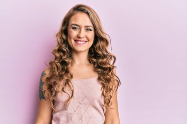 Mutlu ve havalı bir gülüşü olan sıradan kıyafetler giyen genç sarışın kız. şanslı kişi. 