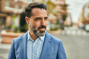 Orta yaşlı işadamı şehirde mutlu mesut dikilirken.