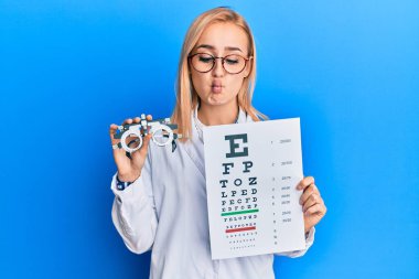 Güzel beyaz gözlüklü kadın elinde optometri gözlüğü ve sağlık muayenesi ile balık suratlı ve şaşı gözlü çılgın ve komik bir kadın.. 