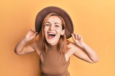 Kafkasyalı genç bir kadın şapkasını takıp kahkahalarla gülüyor.. 