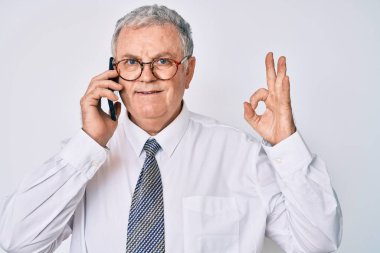 Kıdemli, gri saçlı, iş kıyafetleri giyen, akıllı telefonda konuşan, parmaklarıyla imza atan, güler yüzlü, dost canlısı, mükemmel bir sembol. 