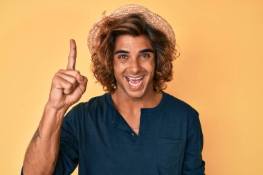 Genç İspanyol şapkalı adam başarılı bir fikirle işaret ediyor. Heyecanlı ve mutlu. Bir numara.. 