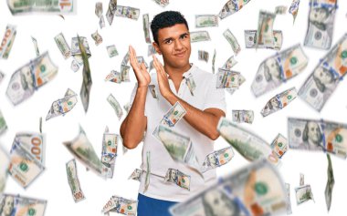 Genç Arap adam gündelik giysiler giyip alkışlıyor ve mutlu ve neşeli, gururlu elleri bir arada alkışlıyor.