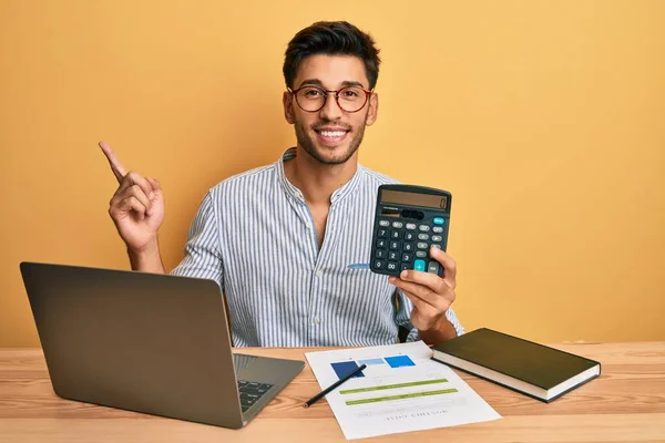 Młody Człowiek Pomocą Kalkulatora Trzymając Ekran Laptopa Pokazujący Palec Kopii — Zdjęcie stockowe