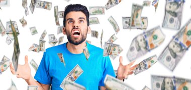 Sakallı, sıradan tişörtlü, deli gibi bağıran, sinirli ifadeli ve kollarını kaldırmış genç yakışıklı bir adam. hüsran kavramı.