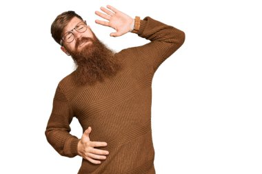 Genç İrlandalı kızıl elbiseli ve gözlüklü, yorgun ve rahat, uykulu ve sabahın erken saatleri için esniyor. 