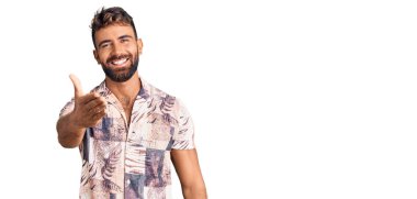 Yaz kıyafetleri giymiş genç İspanyol bir adam gülümseyerek selamlama ve hoş geldin demek için tokalaşmayı teklif ediyor. başarılı iş. 