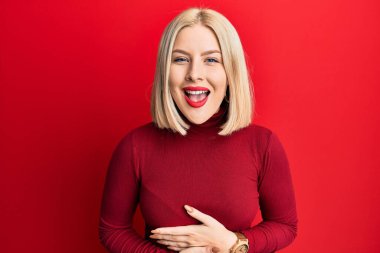 Sıradan kıyafetler giyen genç sarışın kadın gülümseyerek kahkahalarla gülüyor çünkü elleri vücutta olan komik, çılgın bir şaka.. 