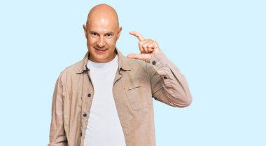 Orta yaşlı, kel, günlük kıyafetler giyen, gülümseyen, kendine güvenen, el hareketleriyle hareket eden, parmaklarıyla işaret yapan ve kameraya bakan bir adam. ölçüm kavramı. 