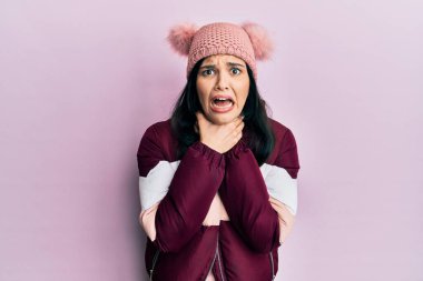 Genç İspanyol kadın yün kazak ve kep giyip bağırıyor ve boğuluyor çünkü acı verici bir boğulma var. Sağlık problemi. Boğulma ve intihar konsepti. 