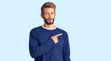 Sakallı, sıradan kazaklı yakışıklı bir adam. El parmağı yanda, ciddi ve sakin bir yüz ifadesi sergiliyor. 