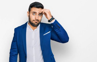 İş ceketi giyen genç İspanyol adam, alnında bir sorun olduğu için endişeli ve stresli. Kriz için endişeli. 