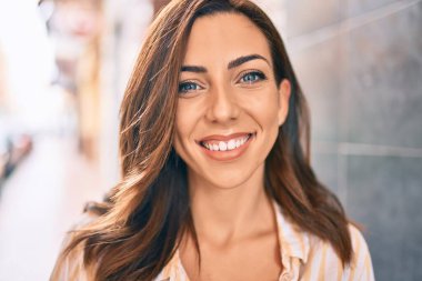 Genç İspanyol kadın gülümseyerek şehirde mutlu mesut yürüyor..