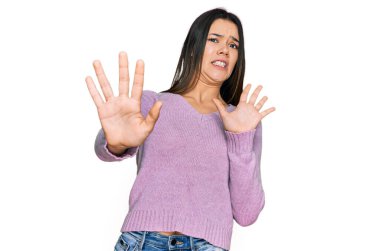 Günlük kıyafetler giyen genç İspanyol kız korku ifadesinden korkuyor ve dehşete düşüyor. El hareketlerini durdur, şok içinde bağır. panik konsepti. 