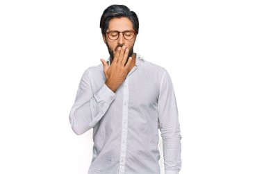 İş gömleği ve gözlük takan İspanyol genç adam ağzıyla ağzını kapatmaktan sıkılmış. Huzursuz ve uykulu.. 