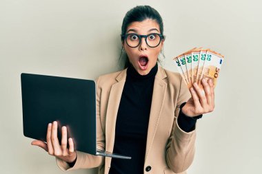 İş stili dizüstü bilgisayar giyen genç İspanyol bir kadın. 50 Euro. Korkuyor ve şok geçiriyor.. 