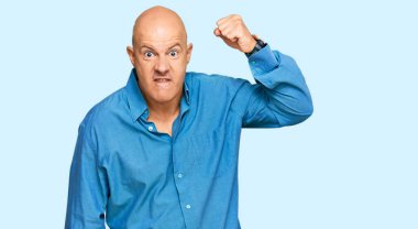 Orta yaşlı, kel bir adam, kızgın ve kızgın. Öfkeyle bağırırken yumruğunu kaldırıyor. öfke ve agresif konsept. 