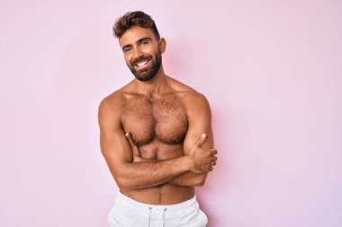 İspanyol asıllı genç adam kollarını kavuşturup kameraya bakarak gülümsüyor. pozitif kişi. 