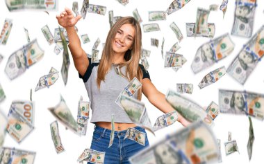 Sıradan kıyafetler giyen genç sarışın kadın kameraya bakıyor ve sarılmak için kollarını açmış gülümsüyor. Mutluluğu kucaklayan neşeli bir ifade..