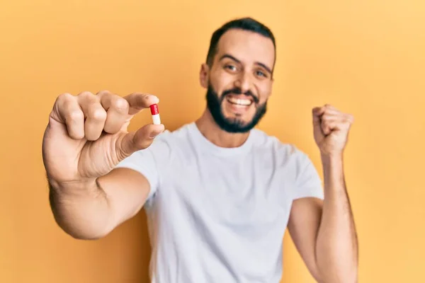 Giovane Uomo Con Barba Tenendo Pillola Urlando Orgoglioso Celebrando Vittoria — Foto Stock