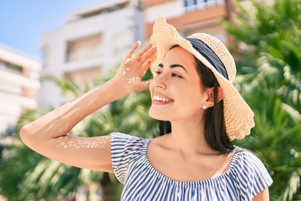 Tatildeki genç Latin turist kız şehirde mutlu gülümsüyor..