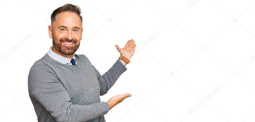 Handsome middle age man wearing business clothes inviting to enter smiling natural with open hand 