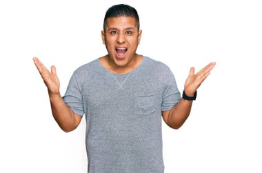 Sıradan kıyafetler giyen genç latin adam çılgın ve başarıyı kollarını kaldırıp heyecanla haykırarak kutluyor. Kazanan konsept 