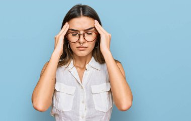 Genç İspanyol kadın gündelik kıyafetler giyiyor. Baş ağrısı, çaresiz ve stresli. Ağrı ve migren yüzünden. Eller başının üstünde.. 