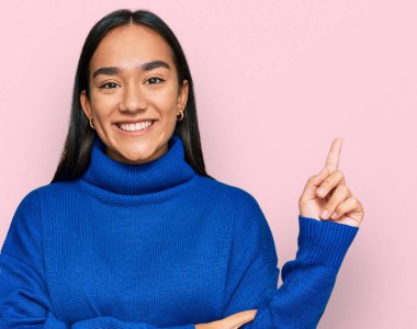 Kış süveteri giyen genç Asyalı kadın gülümsüyor. 