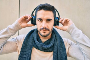 Gevşek yüzlü, şehirde kulaklık takıp müzik dinleyen genç bir İspanyol..