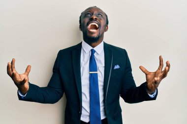 Yakışıklı, takım elbiseli, kravatlı, deli gibi bağıran, agresif ifadeli ve kollarını kaldırmış genç bir zenci. hüsran kavramı. 