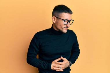 Balıkçı yaka kazak giyen yakışıklı bir adam ve midesinde gözlük olan bir adam. Çünkü hazımsızlık, acı verici bir hastalık ve kendini iyi hissetmiyor. Ağrı kavramı. 