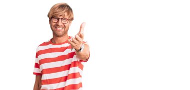 Sakallı, sıradan giyinmiş ve gözlüklü yakışıklı beyaz adam dostça el sıkışma ve hoş geldin demek için gülümsüyor. başarılı iş. 