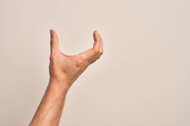 İzole edilmiş beyaz arka plan üzerinde parmaklarını gösteren beyaz bir adamın eli. Görünmez bir şeyi alıp, parmaklarıyla uzayı gösteren bir nesneyi tutuyor.