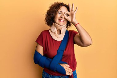 Güzel, orta yaşlı olgun bir kadın boyun tasması takıyor ve kolu askıda gülümsüyor. 