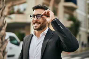 Genç İspanyol işadamı gülümseyerek şehirde mutlu mesut duruyor..