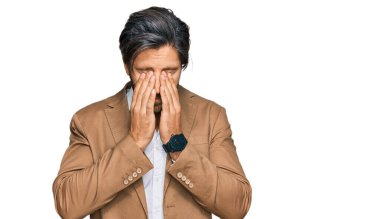 İş kıyafetleri giyen genç İspanyol adam yorgunluk ve baş ağrısı için gözlerini ovuşturuyor, uykulu ve yorgun bir ifade takınıyor. görme sorunu 