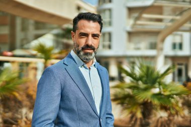 Orta yaşlı işadamı şehirde mutlu mesut dikilirken.