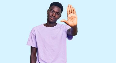 Sıradan kıyafetler giyen genç Afro-Amerikan bir adam avucunun içi gibi şarkı söylemeyi kesiyor. Yüzünde olumsuz ve ciddi bir jest olan uyarı ifadesi. 