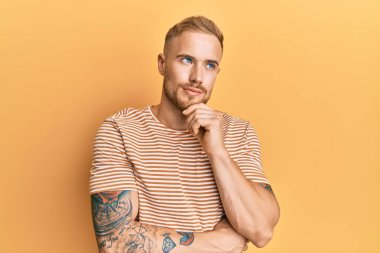 Sıradan çizgili tişört giyen genç beyaz bir adam şüphe üzerine yoğunlaşmıştı. Çenesi parmaklarla çevriliydi ve yukarı bakıyordu. 